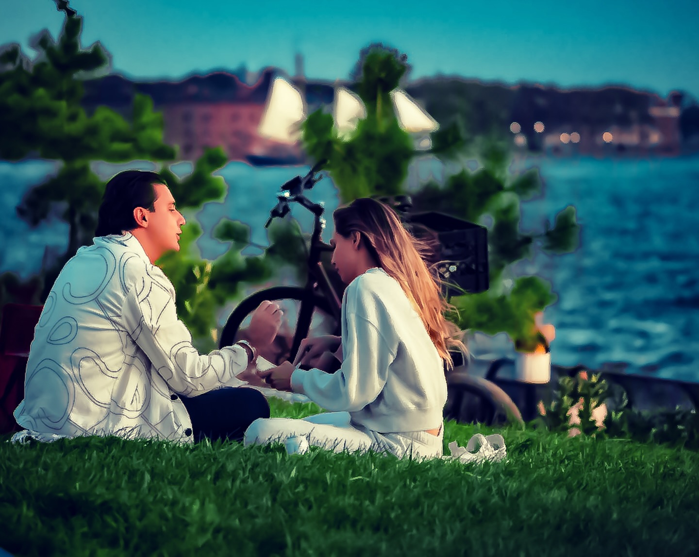 Couple by the water with sailboats behind