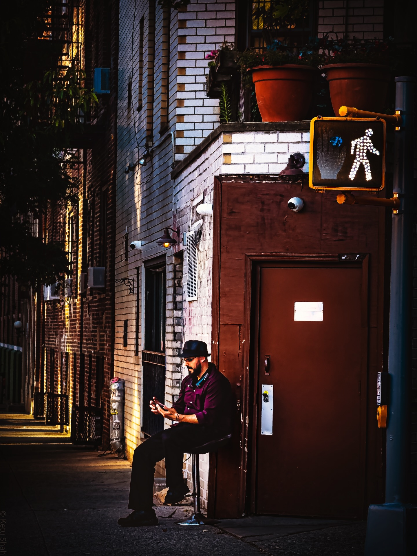 Man sitting outside a building at dusk